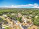 An aerial shot shows houses amongst trees under a sunny blue sky at 1108 Cedar St, Leesburg, FL 34748