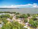 Aerial view showcasing homes near lake and lush landscape under bright blue partly cloudy sky at 1108 Cedar St, Leesburg, FL 34748
