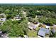 An aerial view capturing a mix of wooded areas and homes in a residential neighborhood, with a view of a waterway at 1108 Cedar St, Leesburg, FL 34748