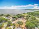Aerial view showcasing houses near a lake surrounded by lush greenery and bright blue sky at 1108 Cedar St, Leesburg, FL 34748