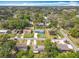 An aerial view of single-Gathering homes within a tree-filled neighborhood with visible streets and driveways at 1108 Cedar St, Leesburg, FL 34748