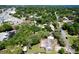 An aerial perspective of a residential neighborhood with trees and houses, next to a commercial area and waterway at 1108 Cedar St, Leesburg, FL 34748