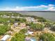 Aerial view showing houses surrounded by lush foliage near a beautiful lake under a blue sky at 1108 Cedar St, Leesburg, FL 34748