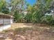 Large backyard featuring mature trees, play equipment, and a screened-in porch for outdoor enjoyment at 1108 Cedar St, Leesburg, FL 34748