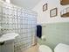 Traditional bathroom featuring light green tile, standard fixtures, and a patterned shower curtain at 1108 Cedar St, Leesburg, FL 34748