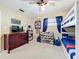 Bright bedroom featuring a bunk bed, ceiling fan, and furniture including a cherry dresser and bookcase at 1108 Cedar St, Leesburg, FL 34748