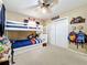 Bright bedroom featuring a bunk bed with storage, a ceiling fan, and unique baseball themed decorations at 1108 Cedar St, Leesburg, FL 34748