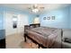 Light blue bedroom featuring a bed, crib, ceiling fan, and a large mirrored closet at 1108 Cedar St, Leesburg, FL 34748