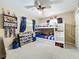 Bright bedroom featuring a bunk bed, ceiling fan, and decorations including a display shelf of baseballs and trophies at 1108 Cedar St, Leesburg, FL 34748