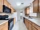 Traditional kitchen featuring wood cabinets, tile floors, and black appliances at 1108 Cedar St, Leesburg, FL 34748