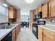 Traditional kitchen featuring wood cabinets, tile floors, and view to the dining room at 1108 Cedar St, Leesburg, FL 34748