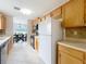 Traditional kitchen featuring wood cabinets, tile floors, and stainless steel appliances at 1108 Cedar St, Leesburg, FL 34748