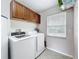 Functional laundry area with appliances, overhead cabinets, and a window providing natural light at 1108 Cedar St, Leesburg, FL 34748