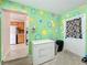 Functional mudroom features colorful walls, chest freezer and easy access to the kitchen at 1108 Cedar St, Leesburg, FL 34748