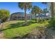 Home exterior featuring screened-in patio, lush green lawn, and swaying palm trees at 114 Cherry Creek Cir, Winter Springs, FL 32708