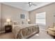 Well-lit bedroom with a patterned comforter, bedside lamps, and natural light from windows at 114 Cherry Creek Cir, Winter Springs, FL 32708