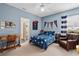 Comfortable blue bedroom with a desk, armchair, and a glimpse into the en-suite bathroom at 114 Cherry Creek Cir, Winter Springs, FL 32708