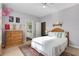 Bright bedroom with a white bed, wooden dresser, neutral walls, and a decorative rug at 114 Cherry Creek Cir, Winter Springs, FL 32708