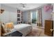 Cozy bedroom featuring a built-in shelving unit, ceiling fan, and natural light from the window at 114 Cherry Creek Cir, Winter Springs, FL 32708