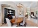 Bright dining room showcasing an oval table, upholstered chairs, china cabinet, and seamless flow to the living room at 114 Cherry Creek Cir, Winter Springs, FL 32708