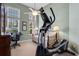 Well-lit workout room with an elliptical machine, desk area, and natural light from multiple windows at 114 Cherry Creek Cir, Winter Springs, FL 32708