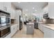 Modern kitchen with stainless appliances, white cabinets, gray backsplash, and an eat-in center island at 114 Cherry Creek Cir, Winter Springs, FL 32708