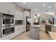 Bright kitchen with stainless appliances, white cabinets, gray backsplash, and an eat-in center island at 114 Cherry Creek Cir, Winter Springs, FL 32708