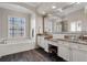 Luxurious main bathroom featuring a garden tub, dual vanity sinks, and natural light at 114 Cherry Creek Cir, Winter Springs, FL 32708