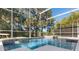 A screened-in pool with a sun shelf, spa, and scenic views of the backyard at 114 Cherry Creek Cir, Winter Springs, FL 32708