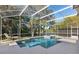 A screened-in pool with sun shelf, hot tub, waterfall, and a comfortable lounge chair to relax at 114 Cherry Creek Cir, Winter Springs, FL 32708