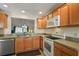 A bright kitchen featuring wooden cabinets, modern appliances, and a view of the outdoor living area at 1197 Eureka Mill Run, The Villages, FL 32162