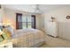 Bright main bedroom featuring a ceiling fan, neutral carpeting, and large window with outdoor view at 1197 Eureka Mill Run, The Villages, FL 32162