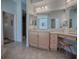 Spacious bathroom vanity featuring dual sinks, a makeup station, and decorative mirrors at 1239 Russell Loop, The Villages, FL 32162