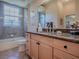 Bathroom featuring a granite vanity, double sinks, large mirror and shower and tub combination at 1239 Russell Loop, The Villages, FL 32162