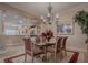 Elegant dining room boasts a chandelier, artwork, and views to the kitchen at 1239 Russell Loop, The Villages, FL 32162