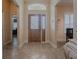 Inviting entryway with leaded glass door, transom window, and tile flooring at 1239 Russell Loop, The Villages, FL 32162