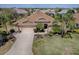 Aerial view of a home with a well-manicured lawn, mature landscaping, and a spacious driveway at 1239 Russell Loop, The Villages, FL 32162