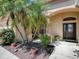 Landscaped front yard featuring mature palm trees and flowering plants at 1239 Russell Loop, The Villages, FL 32162