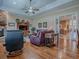 Cozy living room with hardwood floors, a stone fireplace, and comfortable seating at 1239 Russell Loop, The Villages, FL 32162