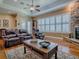 Bright living room with hardwood floors, a stone fireplace, and plantation shutters at 1239 Russell Loop, The Villages, FL 32162