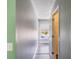 Hallway with neutral paint, hardwood floors, a window offering natural light and entryways to other rooms at 12620 Bay Breeze Ct, Clermont, FL 34711