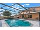 Enjoy the Florida sun by this screened in pool with a covered lanai and outdoor dining area at 12620 Bay Breeze Ct, Clermont, FL 34711