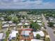 Aerial view of home surrounded by neighborhood, trees, and lake in the distance at 1312 Apache Cir, Tavares, FL 32778