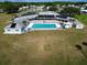 Aerial view highlighting the community pool, surrounded by lush greenery and clubhouse features at 1312 Apache Cir, Tavares, FL 32778