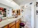 Bright bathroom with oak cabinets, a framed mirror and a walk-in shower at 1312 Apache Cir, Tavares, FL 32778