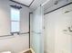 Modern walk-in shower offers a window for light, grab bar and soap dish in bathroom at 1312 Apache Cir, Tavares, FL 32778