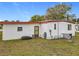 Exterior view of home with white siding, a red roof, and a well-maintained backyard at 1312 Apache Cir, Tavares, FL 32778