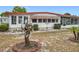 Front exterior of a one-story home featuring an artistic sculpture and an enclosed patio at 1312 Apache Cir, Tavares, FL 32778