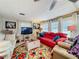 Comfortable living room featuring a red sofa, large windows, and stylish decor at 1312 Apache Cir, Tavares, FL 32778