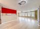 Open-concept living area with wood-look floors, a vibrant red accent wall, and plenty of space at 1312 Apache Cir, Tavares, FL 32778